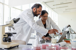 Scientists in lab coats using laptop in laboratory